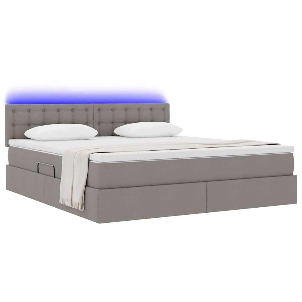Ein modernes grau gepolstertes Bett mit Schubladen zur Aufbewahrung darunter, mit einem gesteppten Kopfteil mit blauer Umgebungsbeleuchtung und einer weißen Bettdecke.
