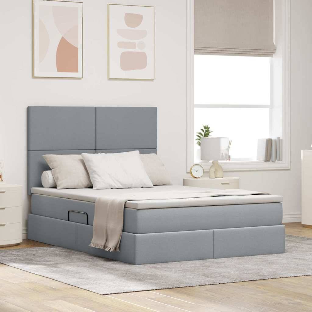 Ein modernes Schlafzimmer mit einem grau gepolsterten Bett, zwei Kissen, einer hellbeige Bettdecke und einem Nachttisch mit einer Lampe und Dekoration. Neutrale Töne schaffen eine ruhige Atmosphäre.