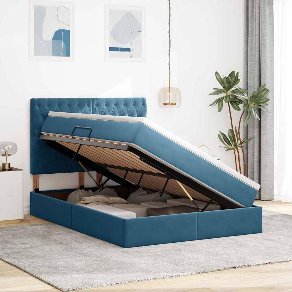 Ein modernes Schlafzimmer mit einem blauen gepolsterten Bett mit Stauraum, wobei die Matratze angehoben ist, um den Stauraum offenzulegen. Beinhaltet eine Pflanze, zwei gerahmte Kunstwerke und sanfte Beleuchtung.