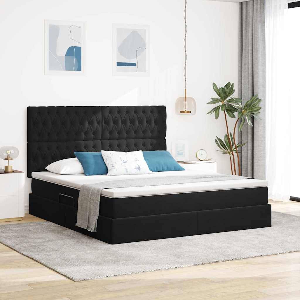 Ein modernes Schlafzimmer mit einem schwarz gepolsterten Bett, weißer Bettwäsche, blauen Akzentkissen und zwei Pendelleuchten. Gerahmte Kunst und eine Topfpflanze runden die Dekoration ab.