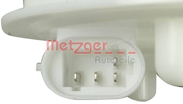 Ein Nahaufnahme eines Connectors mit vier Metallstiften, beschriftet mit ‚Metzger Autoteile' in roter Schrift, was auf ein Automobilbauteil hindeutet.