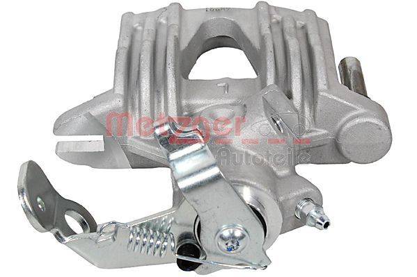Eine Bremssattelkomponente mit Befestigungshardware, mit einer metallisch grauen Oberfläche und einem sichtbaren Federmechanismus.