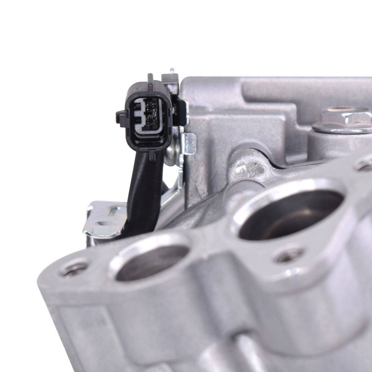 Eine graue Metallmaschinenkomponente mit glatten Oberflächen und einem schwarzen elektrischen Anschluss oben, die in der Automobilmaschinerie verwendet wird.