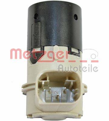 Ein Nahaufnahmebild eines Automotive-Sensors mit Stecker, das einen schwarzen und beigen zylindrischen Anschluss mit drei sichtbaren Metallstiften zeigt.
