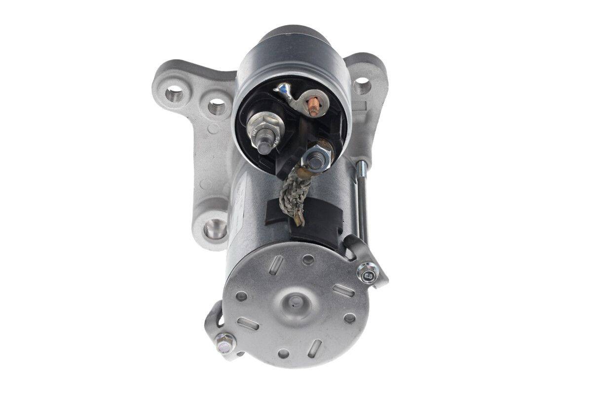 Ein Anlassermotor eines Autos in einer detaillierten Nahaufnahme. Der Metallzylinder hat hervorstehende elektrische Anschlüsse und Befestigungshalterungen.
