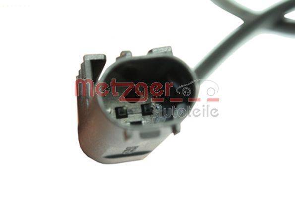 Ein Nahaufnahmebild eines Fahrzeug-Elektrosteckers mit einem grauen Kabel, mit zwei Metallstiften im Inneren. Der Markenname 'Metzger' ist sichtbar.