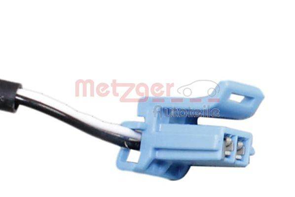 Eine Nahaufnahme eines blauen elektrischen Steckverbinders mit sichtbaren Metallzinken im Inneren, verwendet für automotive Anwendungen. Die Marke 'Metzger' ist im Hintergrund unscharf.