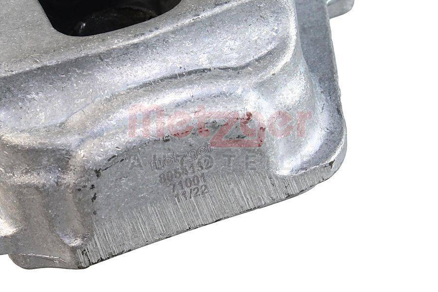 Eine Nahaufnahme eines metallischen Autoteils mit gravierten Zahlen und dem Wort 'Metzger' in Rot.