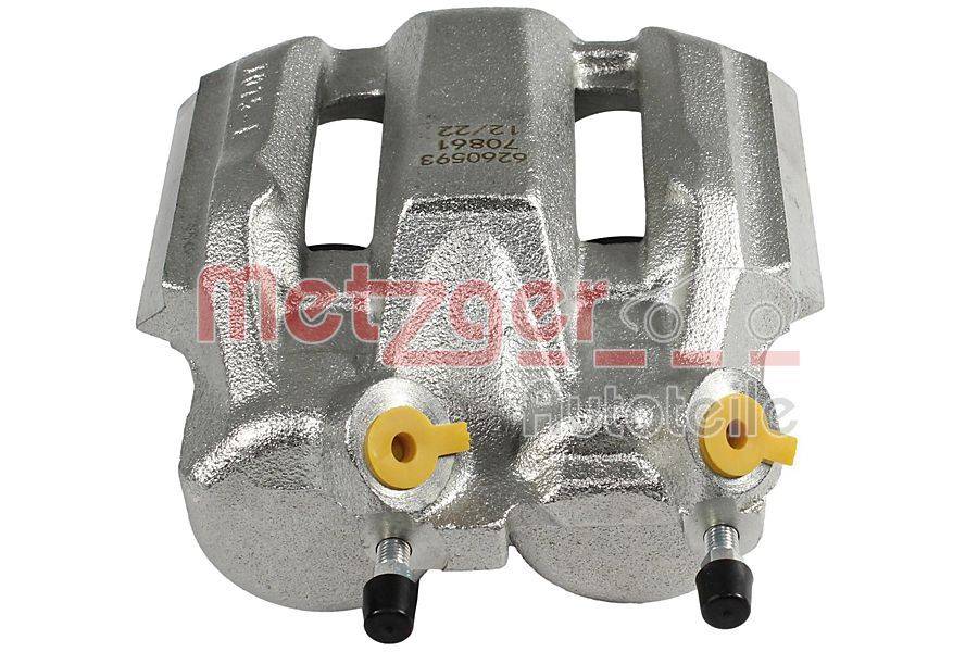 Silberner metallischer Automotive-Bremssattel mit zwei gelben Gummidichtungen und schwarzen Verbindungsstangen, mit der Markenbezeichnung 'Metzger'.