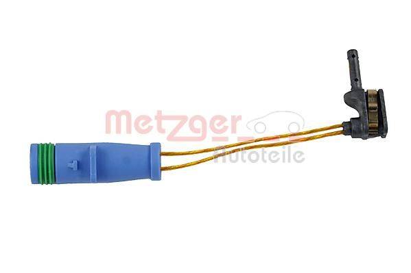 Ein blauer elektrischer Verbinder mit gelben Kabeln, im Hintergrund mit der Beschriftung 
