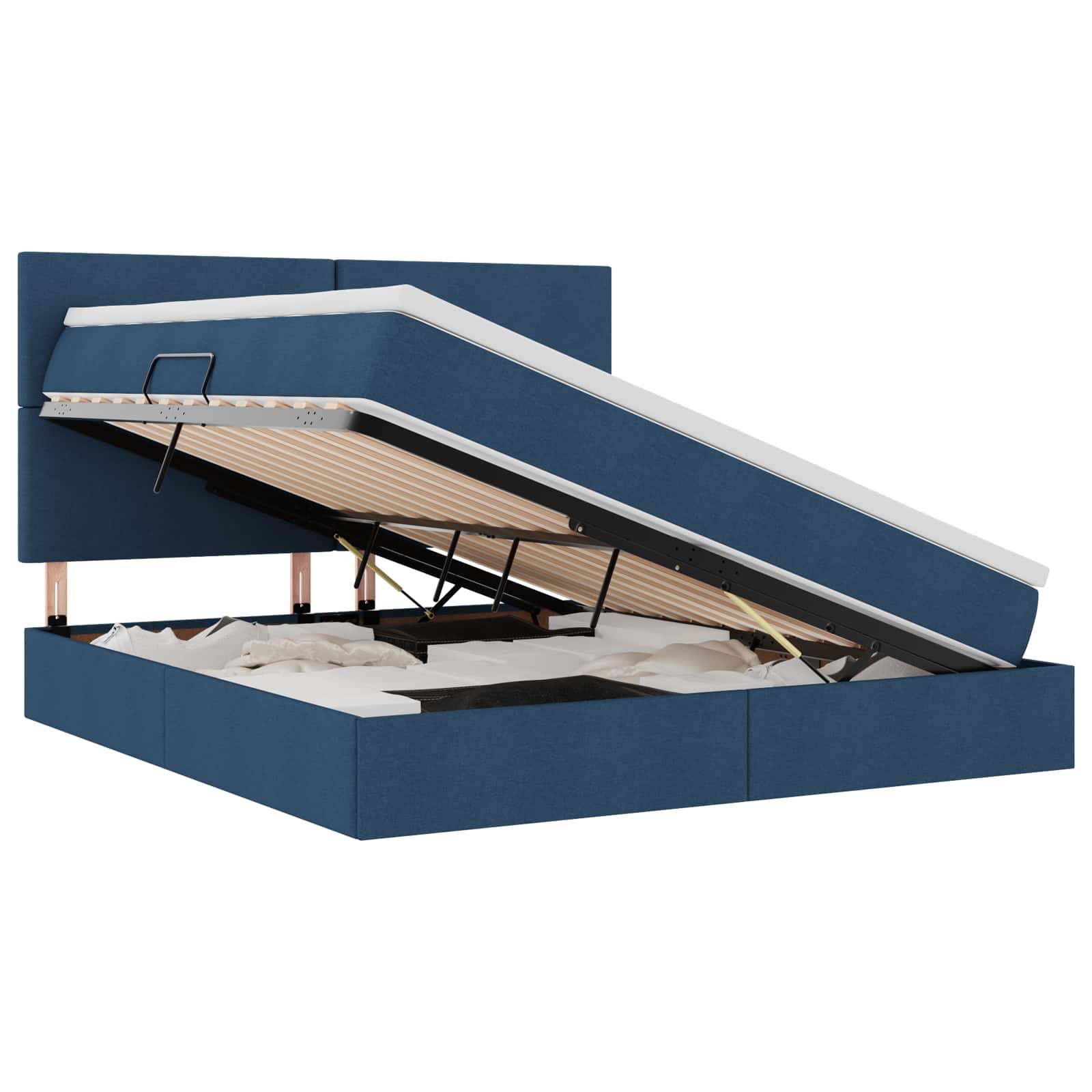 Ein blau gepolstertes Bett mit einem hydraulischen Hubmechanismus offenbart einen Stauraum unter dem Bett, der weiße Bettwäsche enthält.