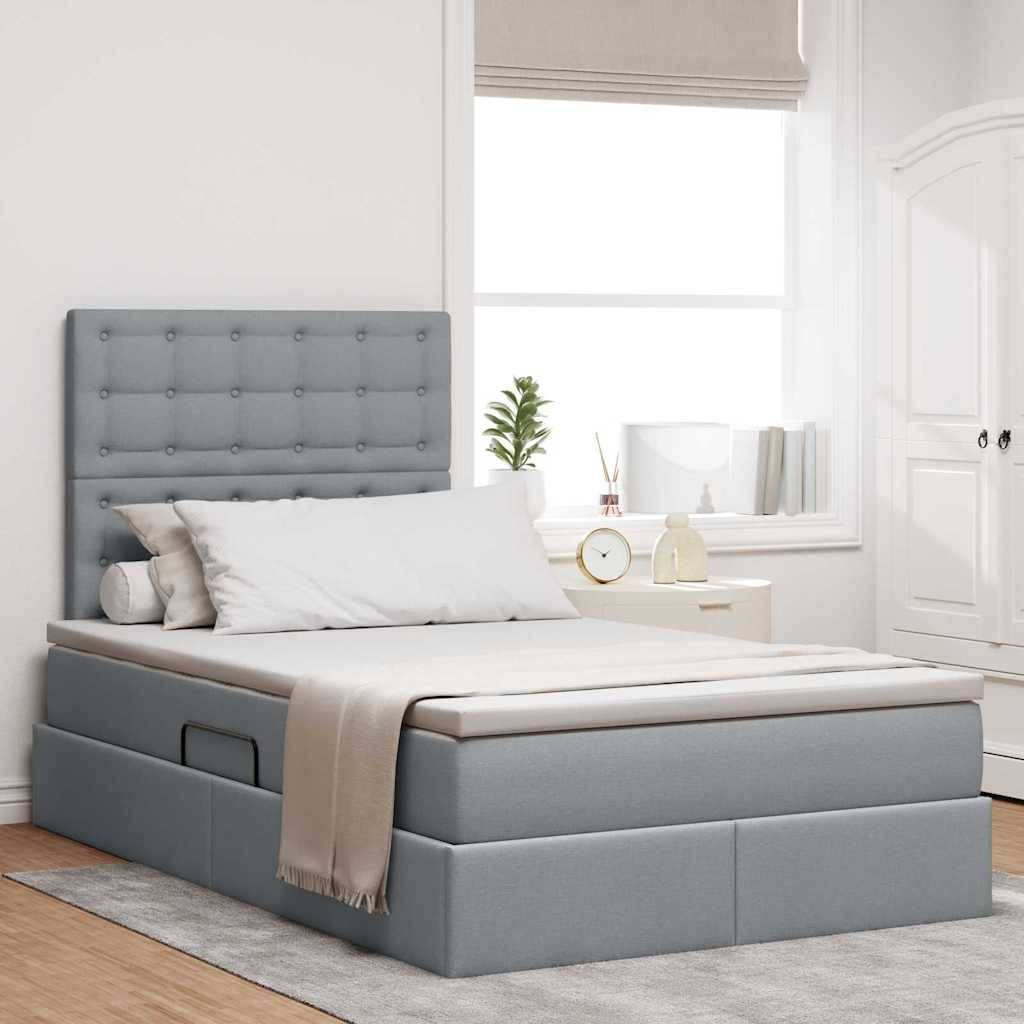 Ein modernes Schlafzimmer verfügt über ein hellgraues gepolstertes Bett mit Schubladen zur Aufbewahrung, neutrale Bettwäsche, einen Nachttisch und sanftes natürliches Licht.