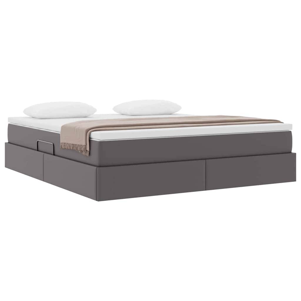 Ein modernes Bett mit einer dicken Matratze, brauner Decke und zwei Kissen, das auf einer dunklen Basis mit integrierten Staurageschubladen steht.
