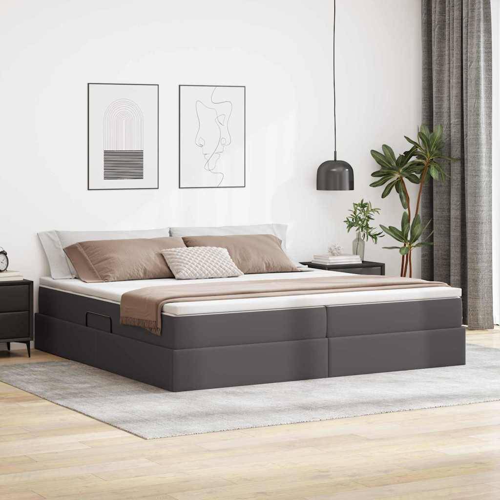 Ein modernes Schlafzimmer präsentiert ein großes Bett mit grauem Rahmen, weißer Bettwäsche und beigefarbener Decke. Zwei minimalistische Kunstwerke hängen über dem Bett. Rechts steht eine Zimmerpflanze.