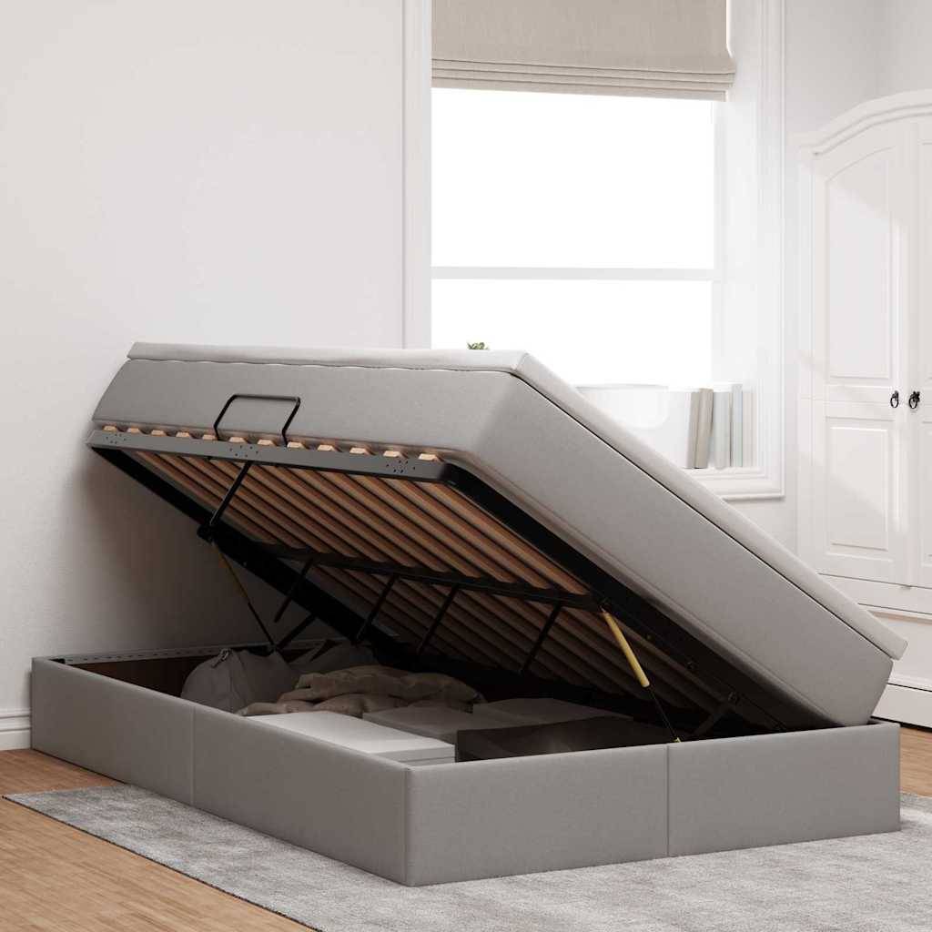 Ein Bett mit einem offenen Stauraum unter der Matratze, auf dem verschiedene Gegenstände gelagert sind.