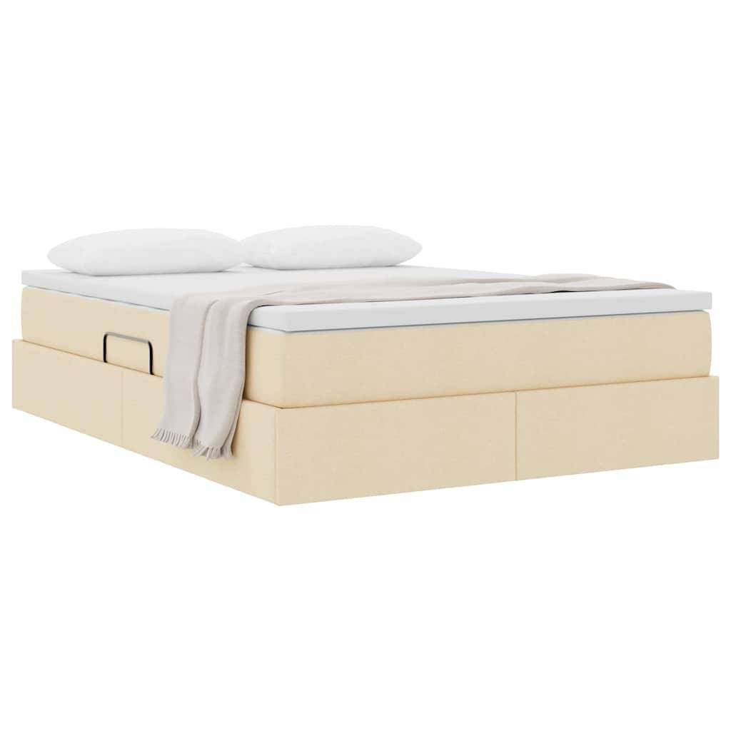 Ein beiges Plattformbett mit einer weißen Matratze, zwei Kissen und einer hellgefärbten Decke, die über die Seite gehängt ist.