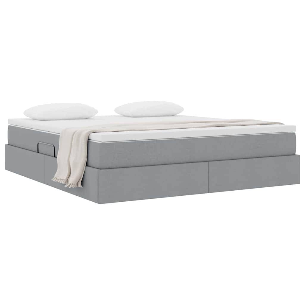 Ein graues Plattformbett mit zwei weißen Kissen und einer beigen Wurfdecke oben, ausgestattet mit zwei Schubladen zur Aufbewahrung an der Seite.