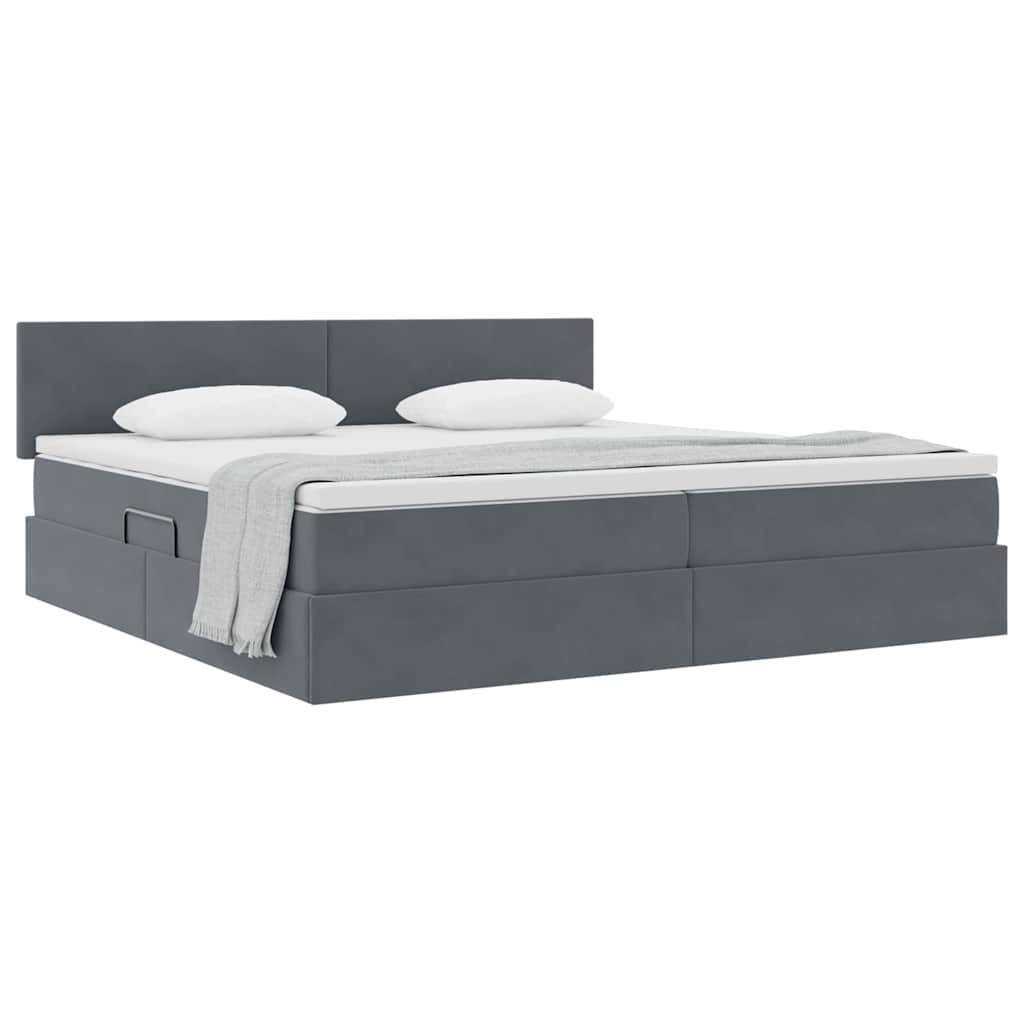 Ein modernes graues Plattformbett mit einem hohen Kopfteil, zwei weißen Kissen und einer hellgrauen Wurfdecke, die ordentlich auf der Matratze angebracht ist.