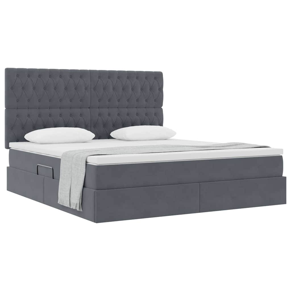 Ein grau gepolstertes Bett mit einer geknöpften Rückenlehne, zwei weißen Kissen, einer hellgrauen Decke und Staurageschubladen darunter.