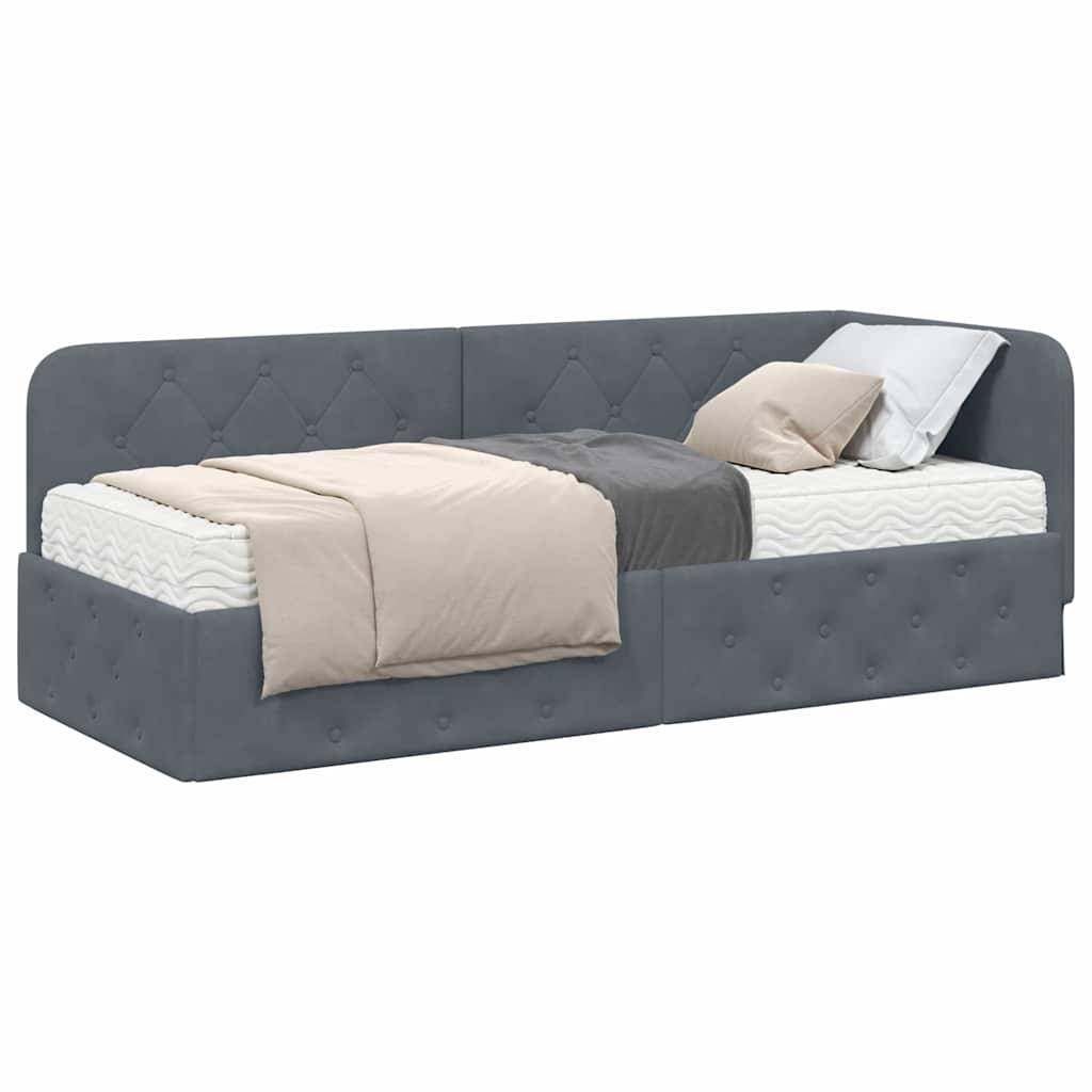 Ein grau gepolstertes Tagesbett mit gestepptem Design, ausgestattet mit einer weißen Matratze, grauer und beiger Bettwäsche sowie zwei Kissen.