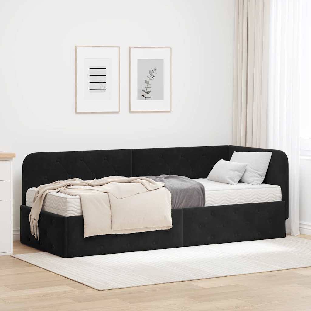 Ein schwarzes gepolstertes Tagesbett mit Bettwäsche und Kissen in einem hellen minimalistischen Schlafzimmer, gestellt gegen eine weiße Wand mit zwei gerahmten Drucken.