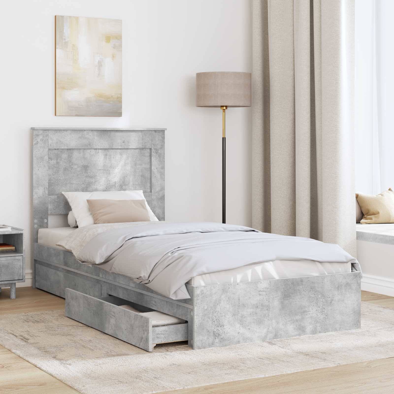 Ein modernes Schlafzimmer mit einem hellgrauen Bett und einer offenen Schublade zur Aufbewahrung darunter. Ein Nachttisch, eine Lampe und Vorhänge tragen zu der gemütlichen Atmosphäre bei.