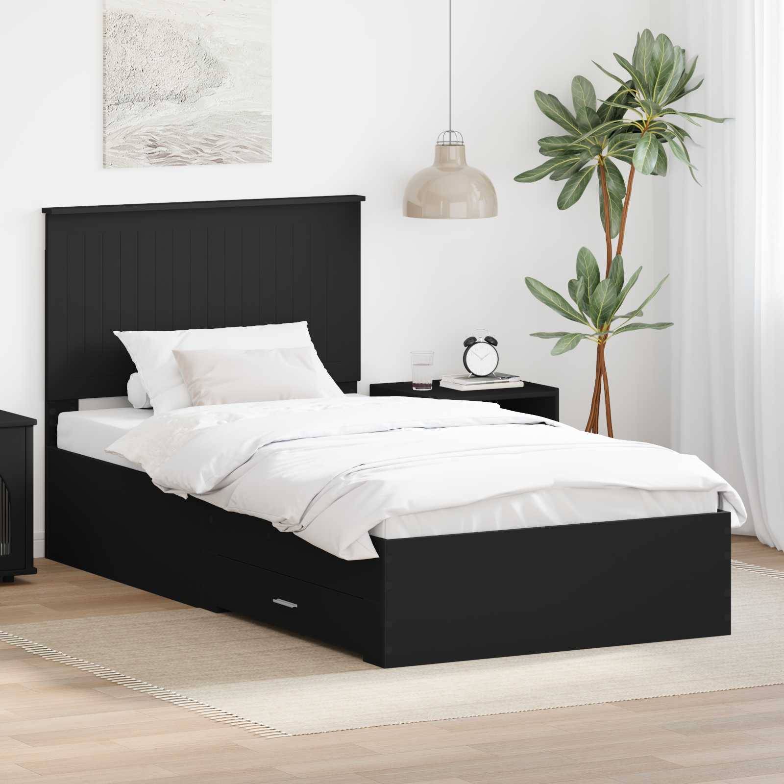 Ein modernes Schlafzimmer mit einem schwarzen Bett und weißer Bettwäsche, ausgestattet mit einem Nachttisch mit einer Lampe und einer Topfpflanze in der Ecke.