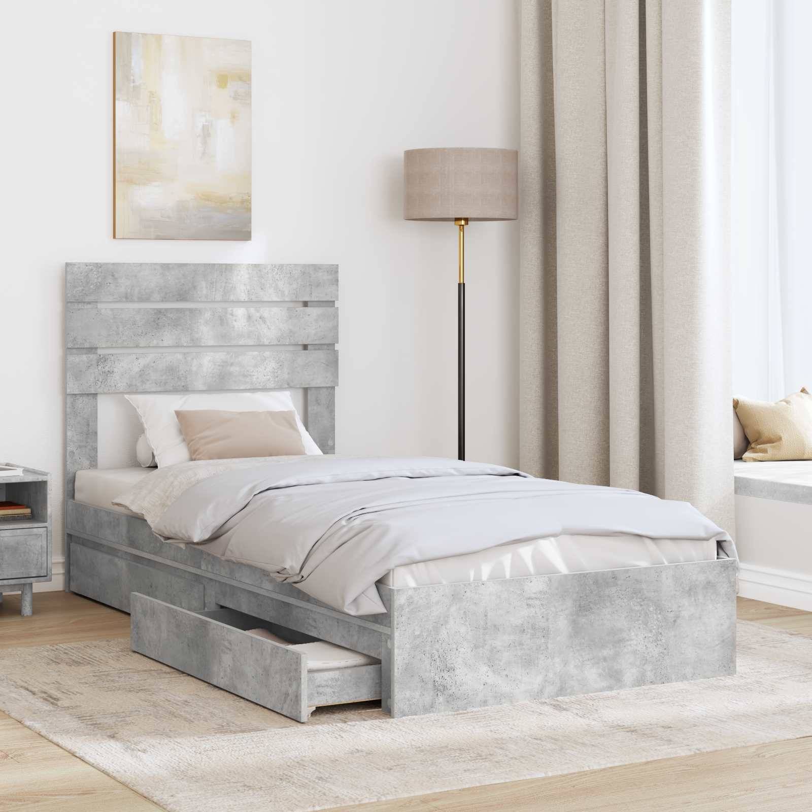 Ein minimalistisches Schlafzimmer mit einem grauen Bett mit Schubladen, hellgrauer Bettwäsche, einem Nachttisch, einer Stehlampe und einer Fensternische.