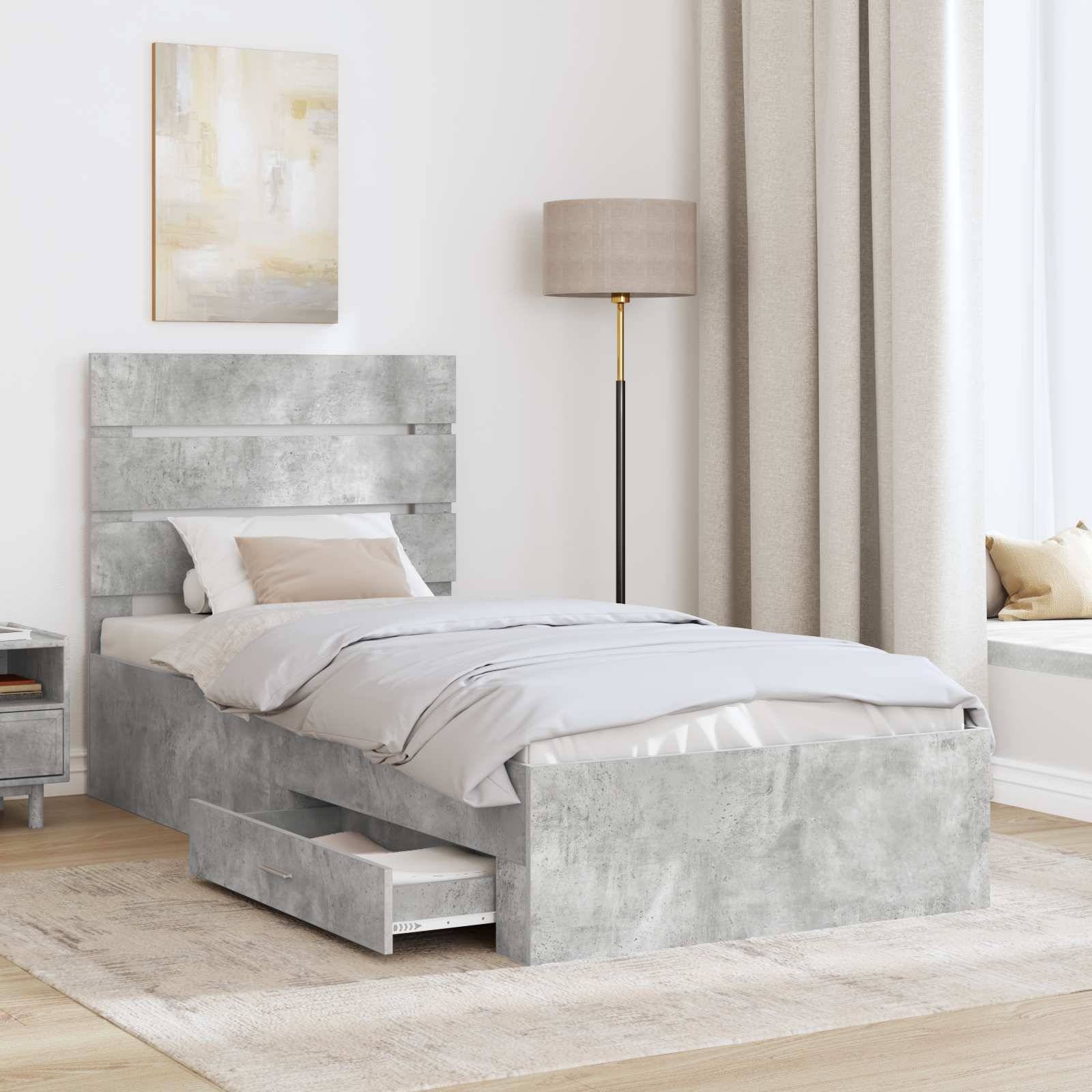 Ein modernes Schlafzimmer mit einem grauen Bett, das Aufbewahrungsschubladen hat, beigefarbener Bettwäsche, einem Gemälde an der Wand und einer Stehlampe neben einem Fensterplatz.