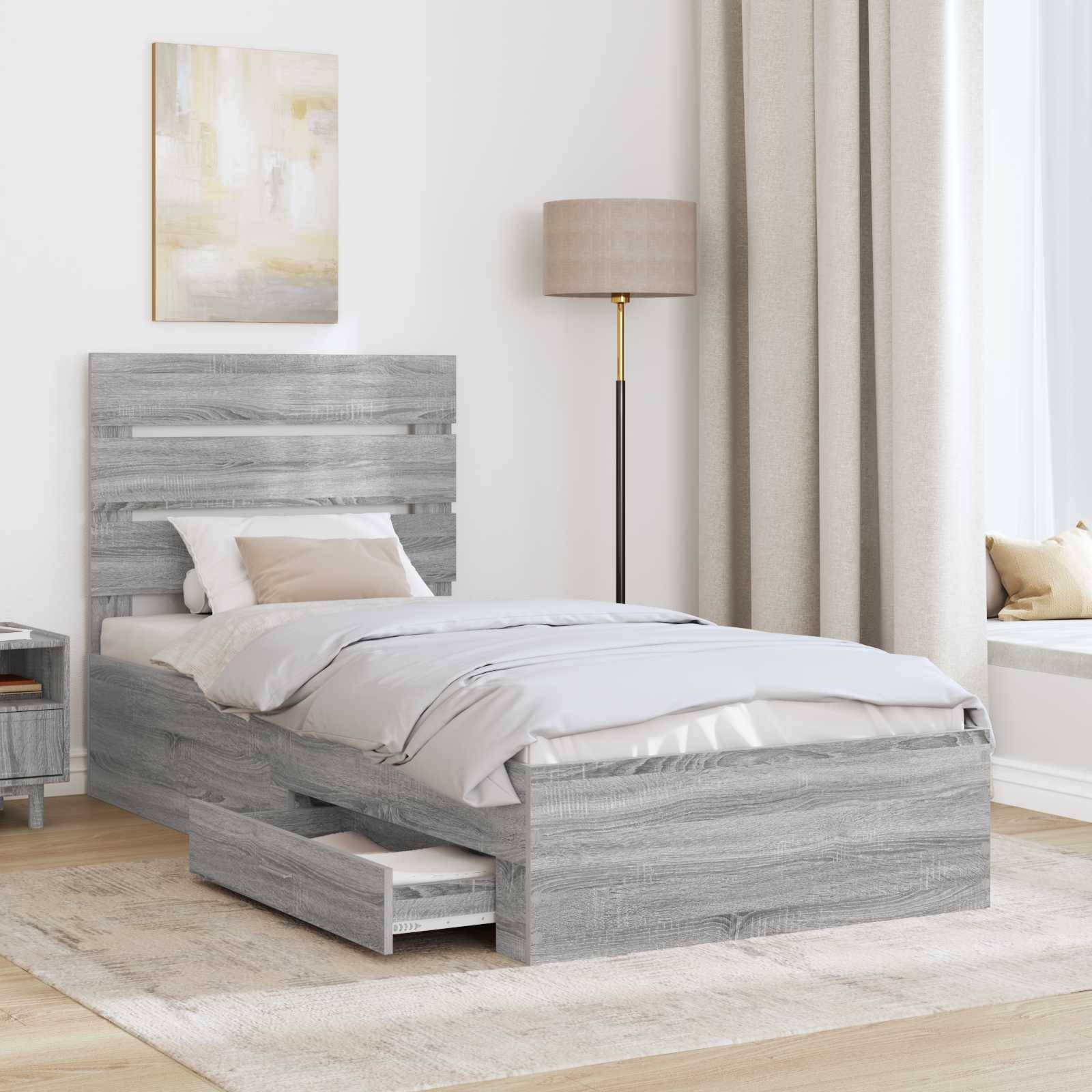 Ein modernes Schlafzimmer verfügt über ein graues Holzbett mit einer integrierten Schublade, neutrale Bettwäsche, eine Stehlampe und eine Fensterbank mit beigen Vorhängen.