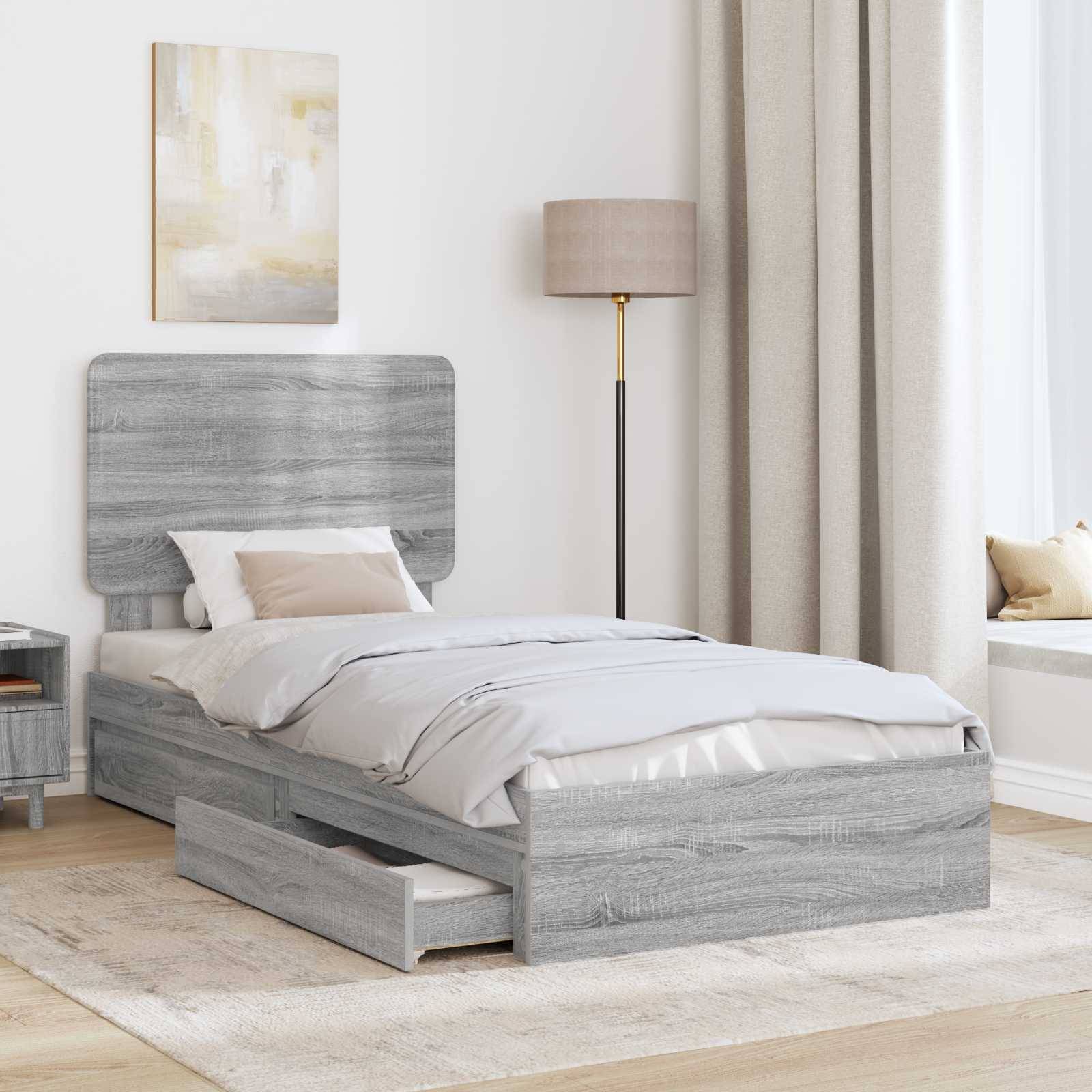 Ein modernes Schlafzimmer mit einem grauen Holzbett mit ausziehbarem Stauraum, weißer Bettwäsche, einem beigen Teppich und einer Stehlampe neben einem großen Fenster.