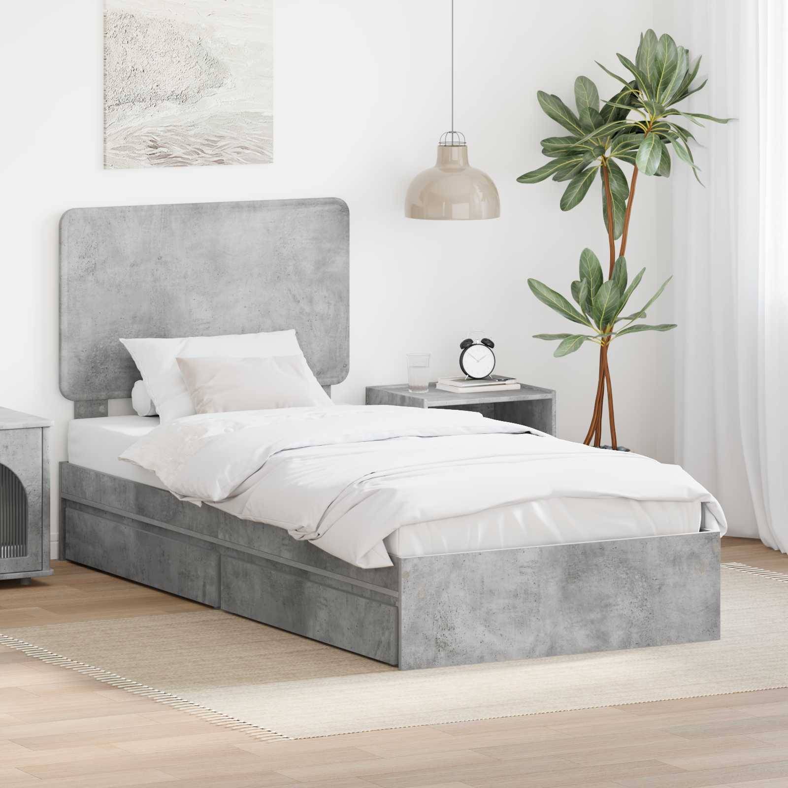 Ein modernes Schlafzimmer mit einem grau gepolsterten Bett, weißer Bettwäsche, einem Nachttisch mit einer Lampe und einer großen grünen Pflanze in der Ecke.
