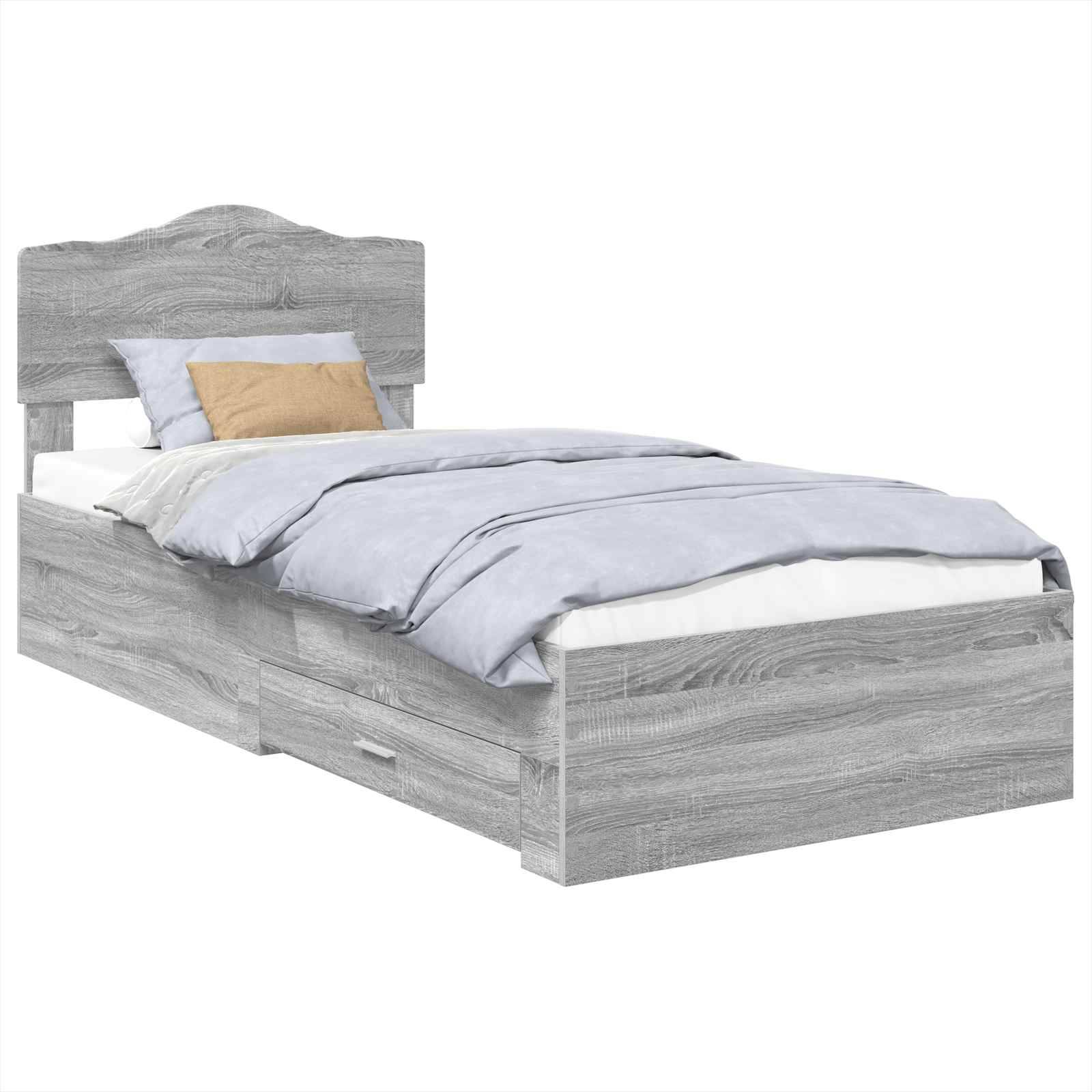 Ein graues Holz-Einzelbett mit Kopfteil ist zu sehen, ausgestattet mit hellblauen Bettwäsche und einem beigen Zierkissen. Darunter befindet sich eine ausziehbare Aufbewahrungsschublade.