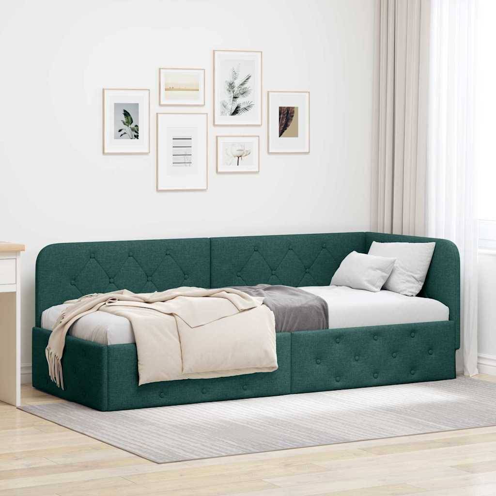 Ein blaugrünes Schlafsofa mit einer beigen Decke und Kissen, platziert in einem hellen Raum mit gerahmten Kunstwerken an der Wand und transparenten Vorhängen am Fenster.