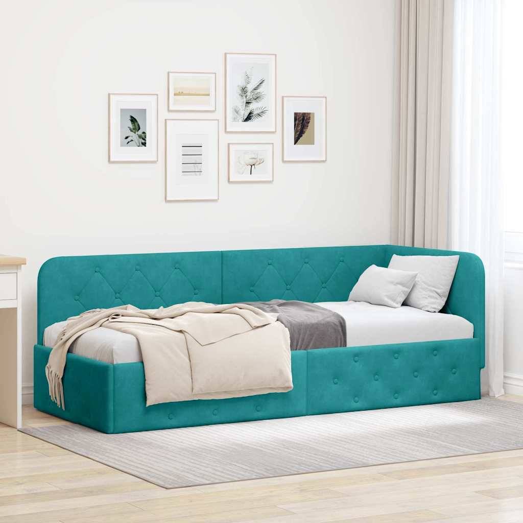 Ein tealpfarbenes Tagesbett mit einer beigen Wurfdecke und Kissen steht in einem hellen Raum. Die Wand ist mit sechs kleinen gerahmten Kunstwerken verziert.
