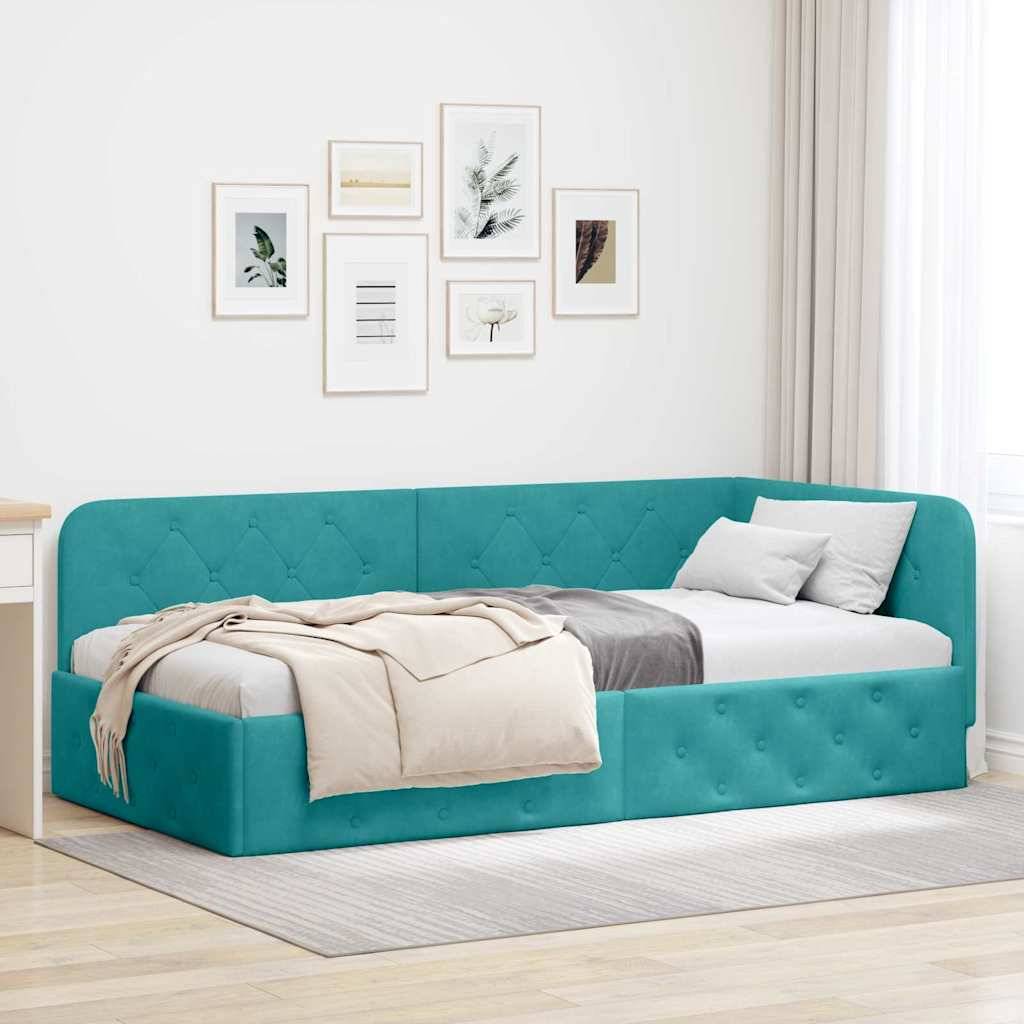 Ein blaugrünes Tagesbett mit gesteppter Polsterung, verziert mit neutralen Kissen und einer beigen Wurfdecke, steht in einem hellen Raum mit gerahmten Kunstwerken an der Wand.