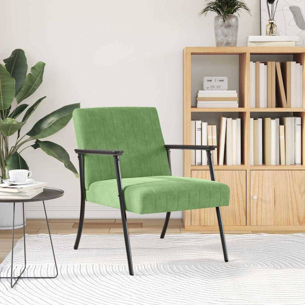Ein moderner Wohnraum mit einem grünen Sessel auf einem hellen Teppich, neben einem runden Couchtisch mit Deko, einer blattreichen Pflanze und einem Holzbücherregal.
