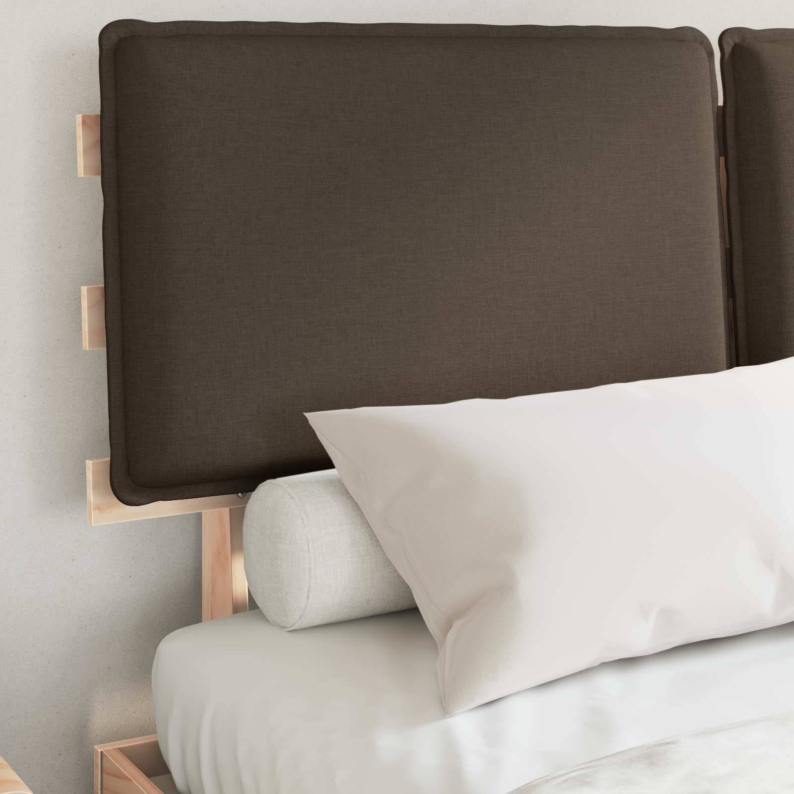 Ein ordentlich gemachtes Bett mit einem braunen Kopfteil, weißen Kissen und einem hellgrauen Nackenrollo, vor einer hellgefärbten Wand.
