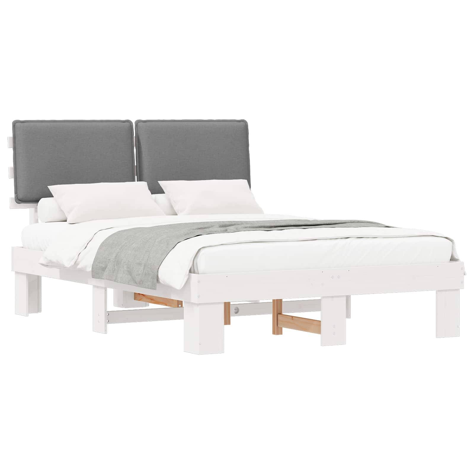 Ein weißer Holzbettrahmen mit einem grauen Kopfteil, weißer Bettwäsche und einer zusammengelegten grauen Decke obenauf.