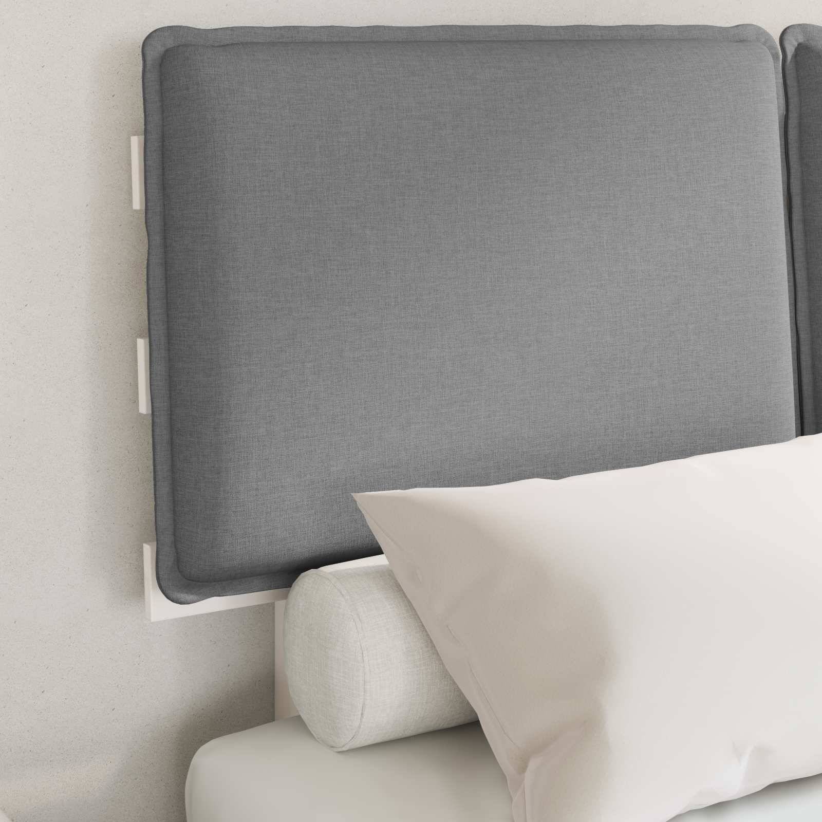 Ein ordentlich gemachtes Bett mit einem grauen gepolsterten Kopfteil, einem weißen Kissen und einem zylindrischen Kissen. Die Umgebung ist minimalistisch und ruhig.