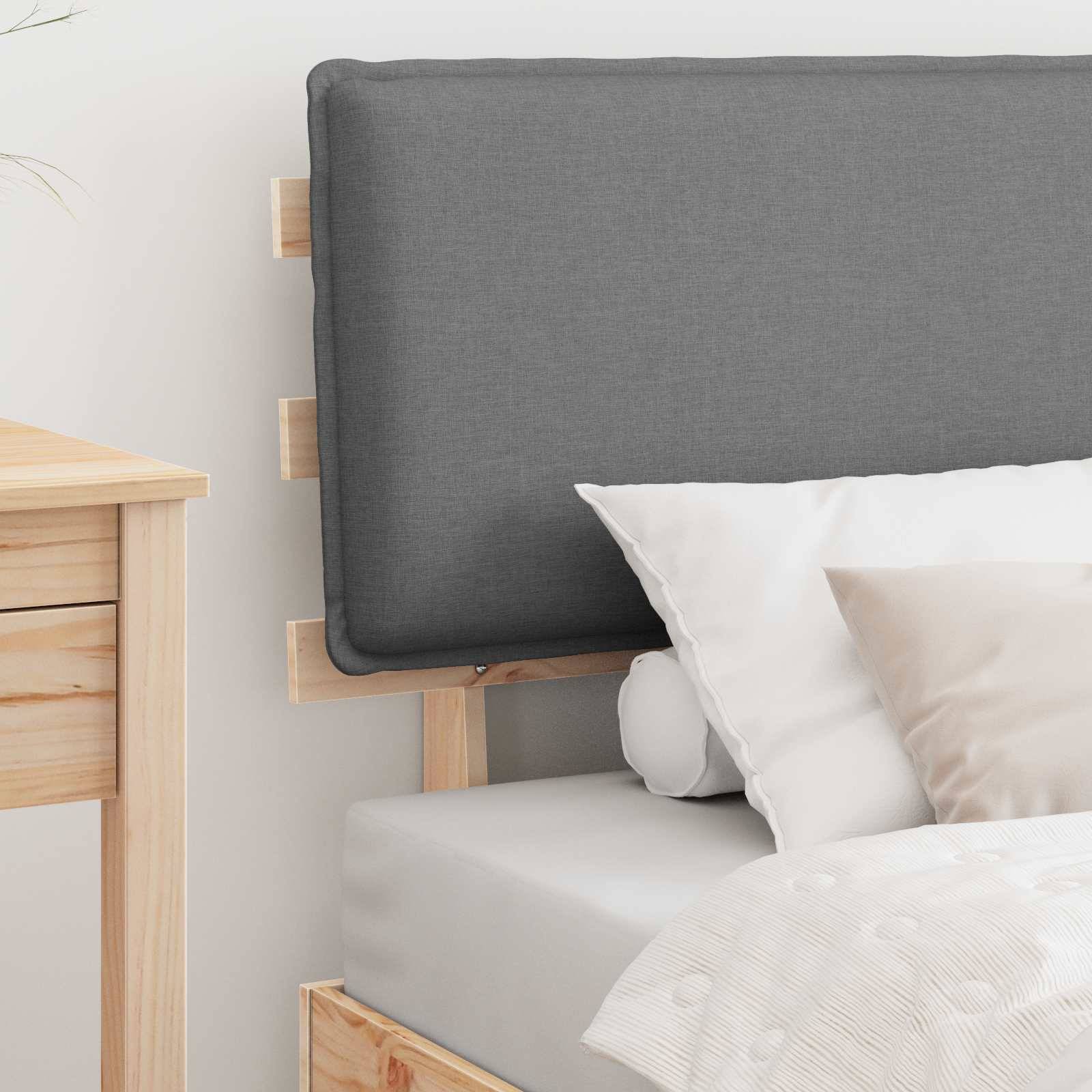 Eine Nahaufnahme eines ordentlich gemachten Bettes mit einem grauen gepolsterten Kopfteil, weißen Kissen und einer hellgrauen Decke in einem minimalistischen Schlafzimmerambiente.