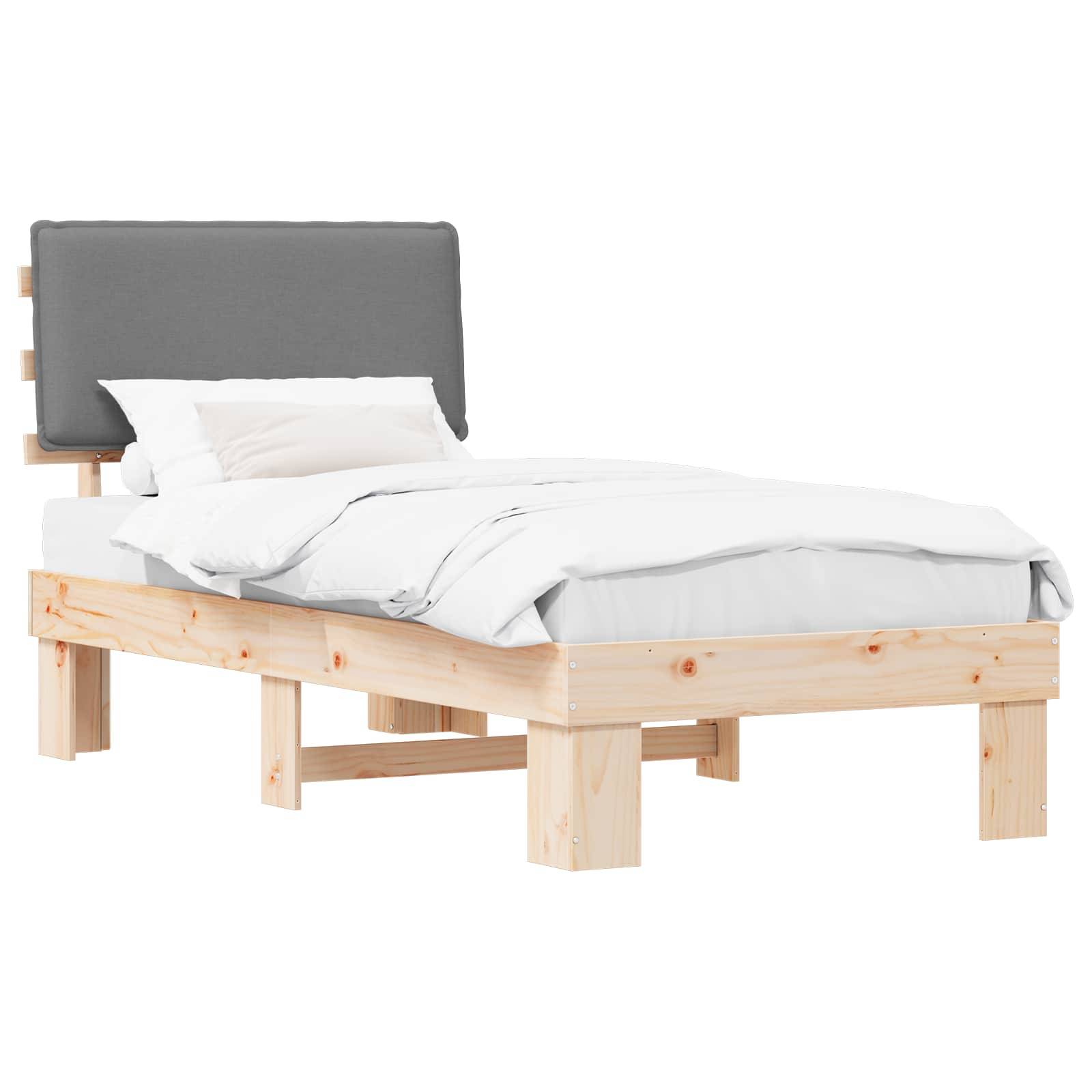 Ein Holzbettgestell mit einem grauen gepolsterten Kopfteil, gezeigt mit weißer Bettwäsche und Kissen. Der Rahmen ist minimalistisch und erhöht.