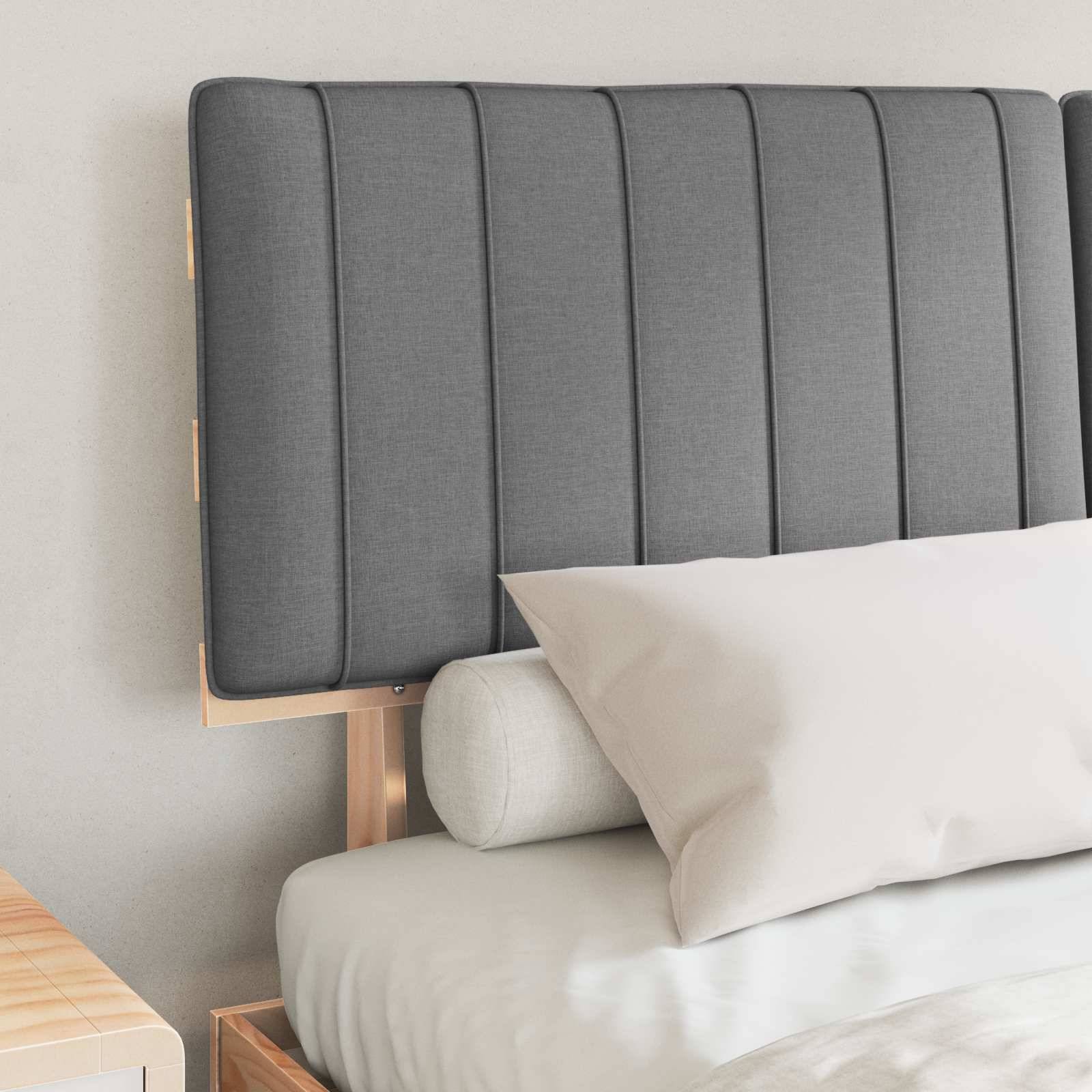 Ein ordentlich gemachtes Bett mit einem grauen gepolsterten Kopfteil, weißem Kissen und Zierkissen, in einer modernen, minimalistischen Schlafzimmeratmosphäre.