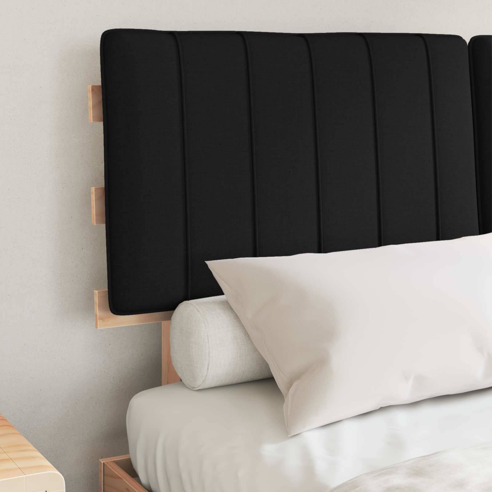 Ein sauber gemachtes Bett mit einem schwarzen gepolsterten Kopfteil, einem weißen Kissen und einem zylindrischen Kissen. Schlichtes, modernes Schlafzimmerdesign.