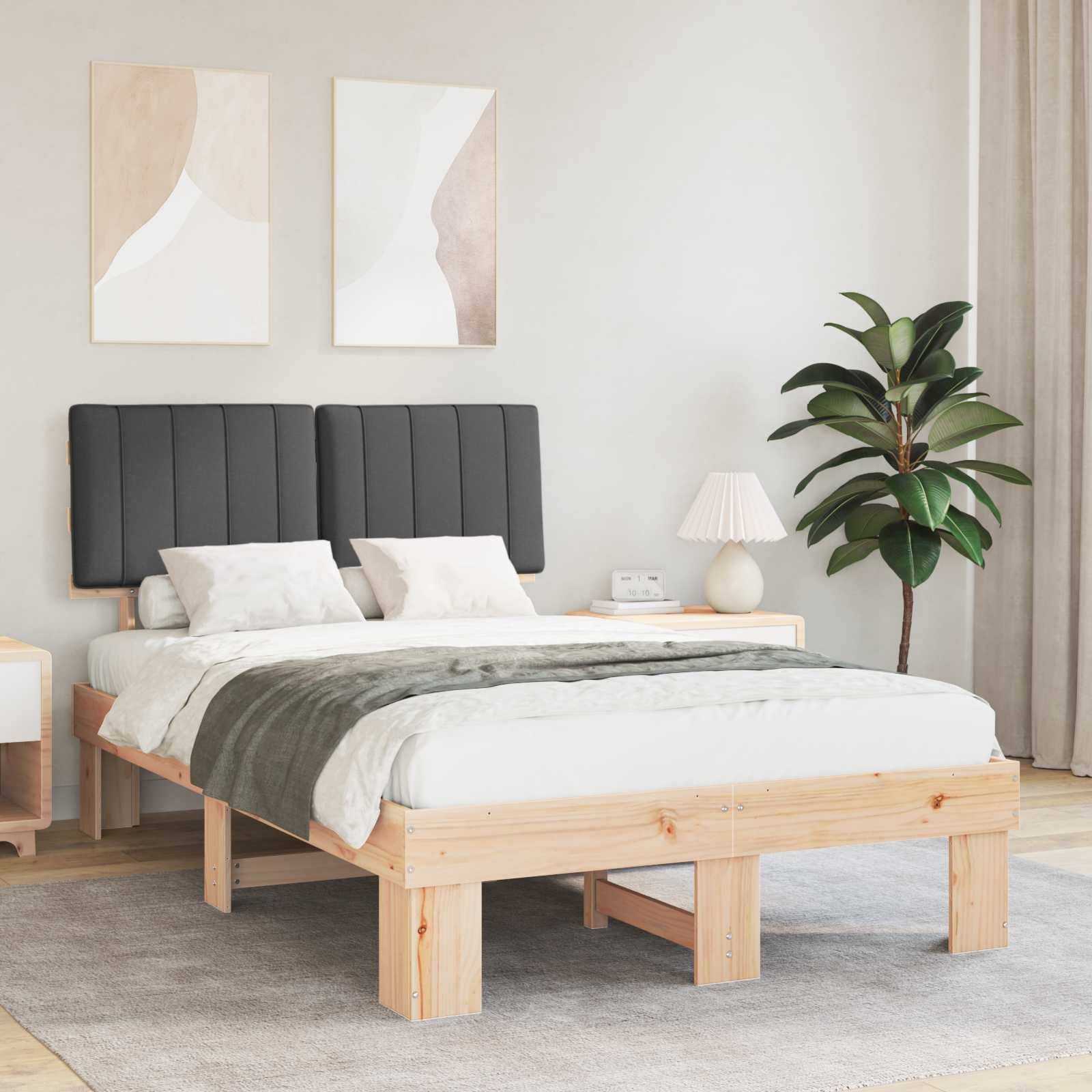 Ein modernes Schlafzimmer mit einem hölzernen Bett mit grauer Bettwäsche, passenden Nachttischen, abstrakten Wandgemälden und einer Topfpflanze in der Ecke.