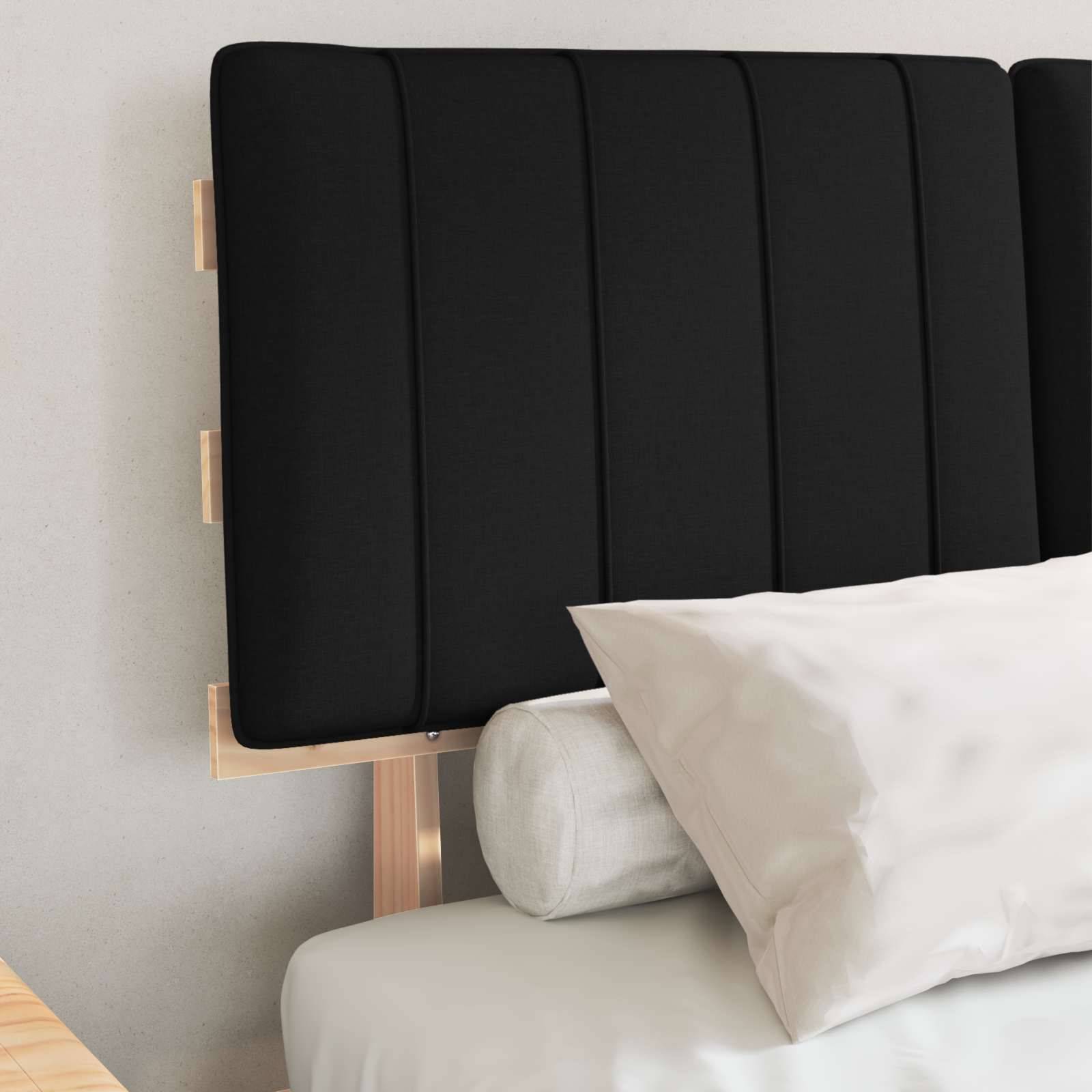 Ein sauber gemachtes Bett mit einem schwarzen gepolsterten Kopfteil und weißen Kissen in einem hellen Raum.