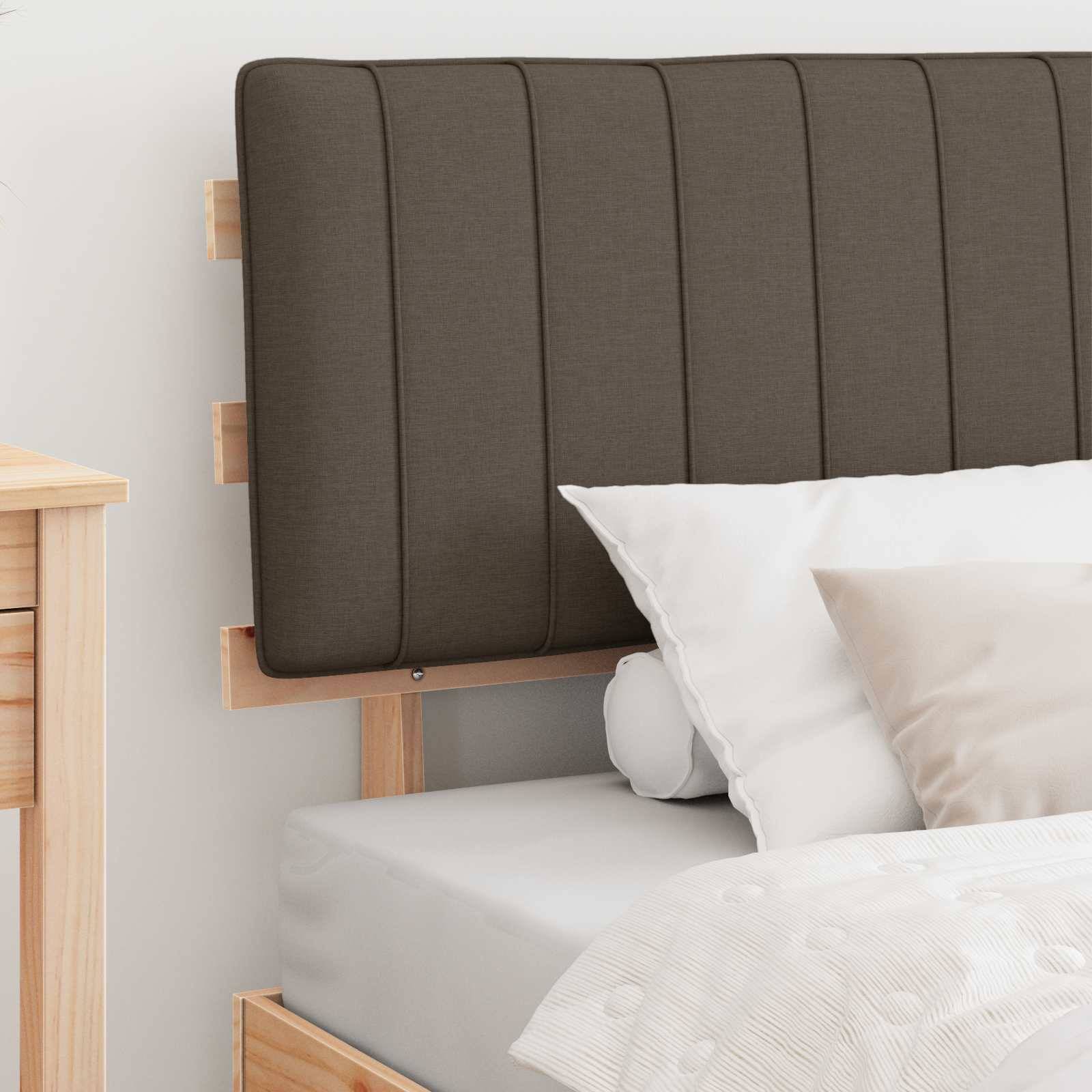 Eine gemütliche Schlafzimmerecke mit einem Holzbett, das einen dunklen, gepolsterten Kopfteil, weiße Bettwäsche und ein beiges Kissen hat. Ein Holznachttisch ist teilweise links zu sehen.