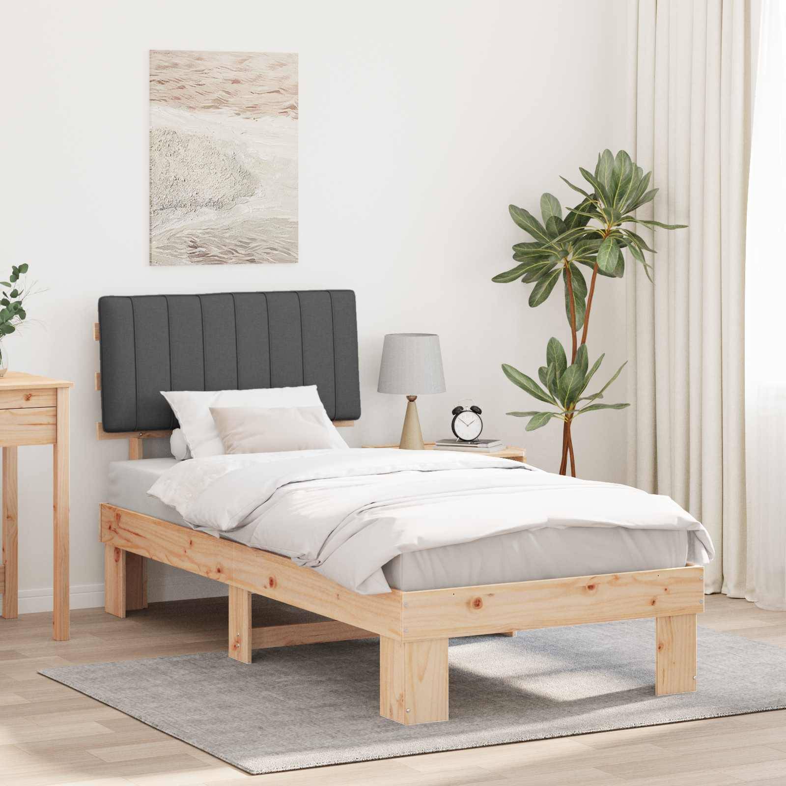 Ein minimalistisches Schlafzimmer mit einem Holzbett, weißer Bettwäsche, einem kleinen Holzschreibtisch, einer Pflanze, einem Nachttisch mit einer Lampe und einem dekorativen Wandgemälde.