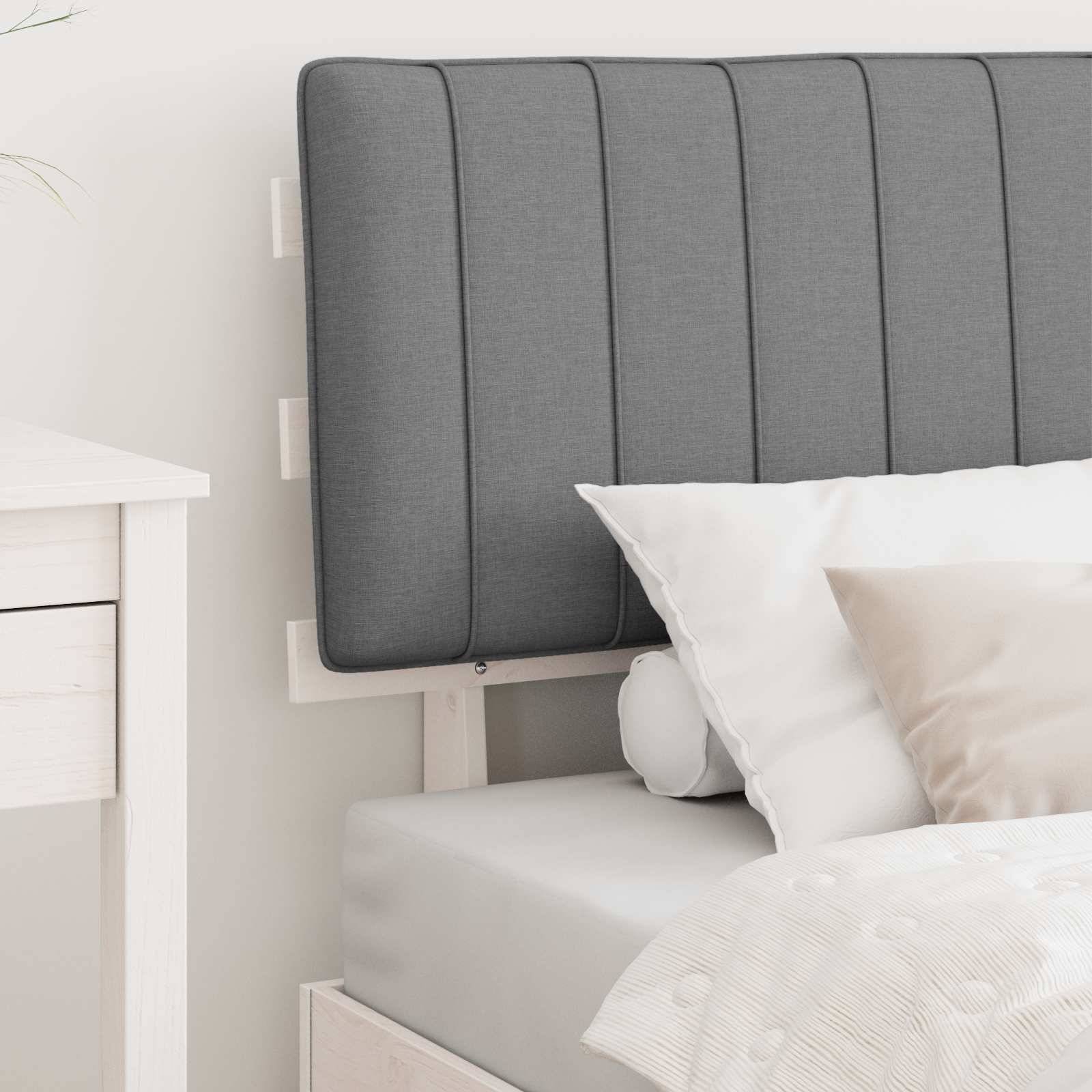 Grauer getufteter Kopfteil und Kissen auf einem ordentlich gemachten Bett in einem hellen, minimalistischen Schlafzimmer mit helzfarbener Möbelausstattung.