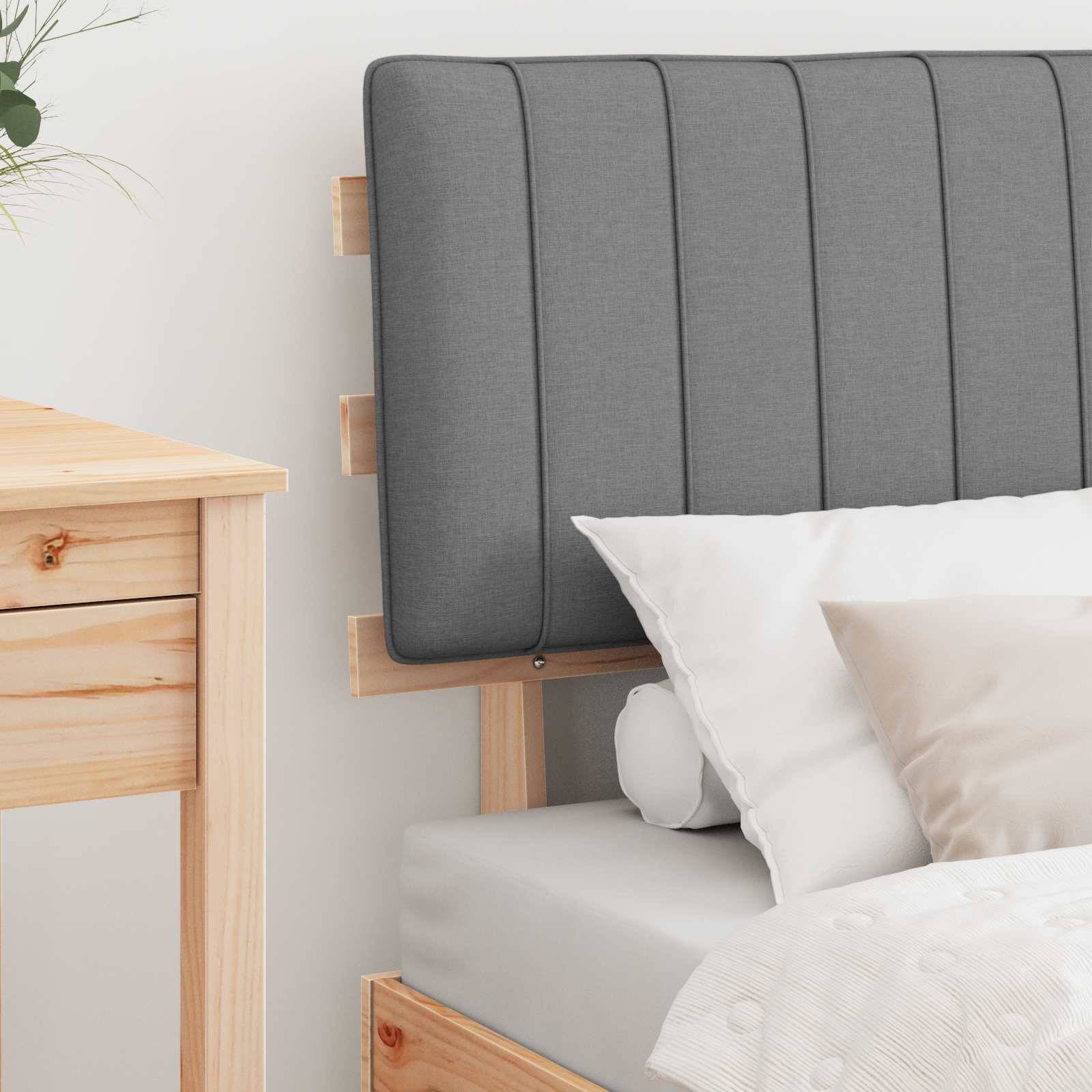 Eine gemütliche Schlafzimmerecke zeigt ein helles Holzbett mit einem grauen gepolsterten Kopfteil, weißer Bettwäsche und einem Holznachttisch.